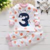 Kinderpyjama, konijn met nummer "3" en speelse oranje stippen.